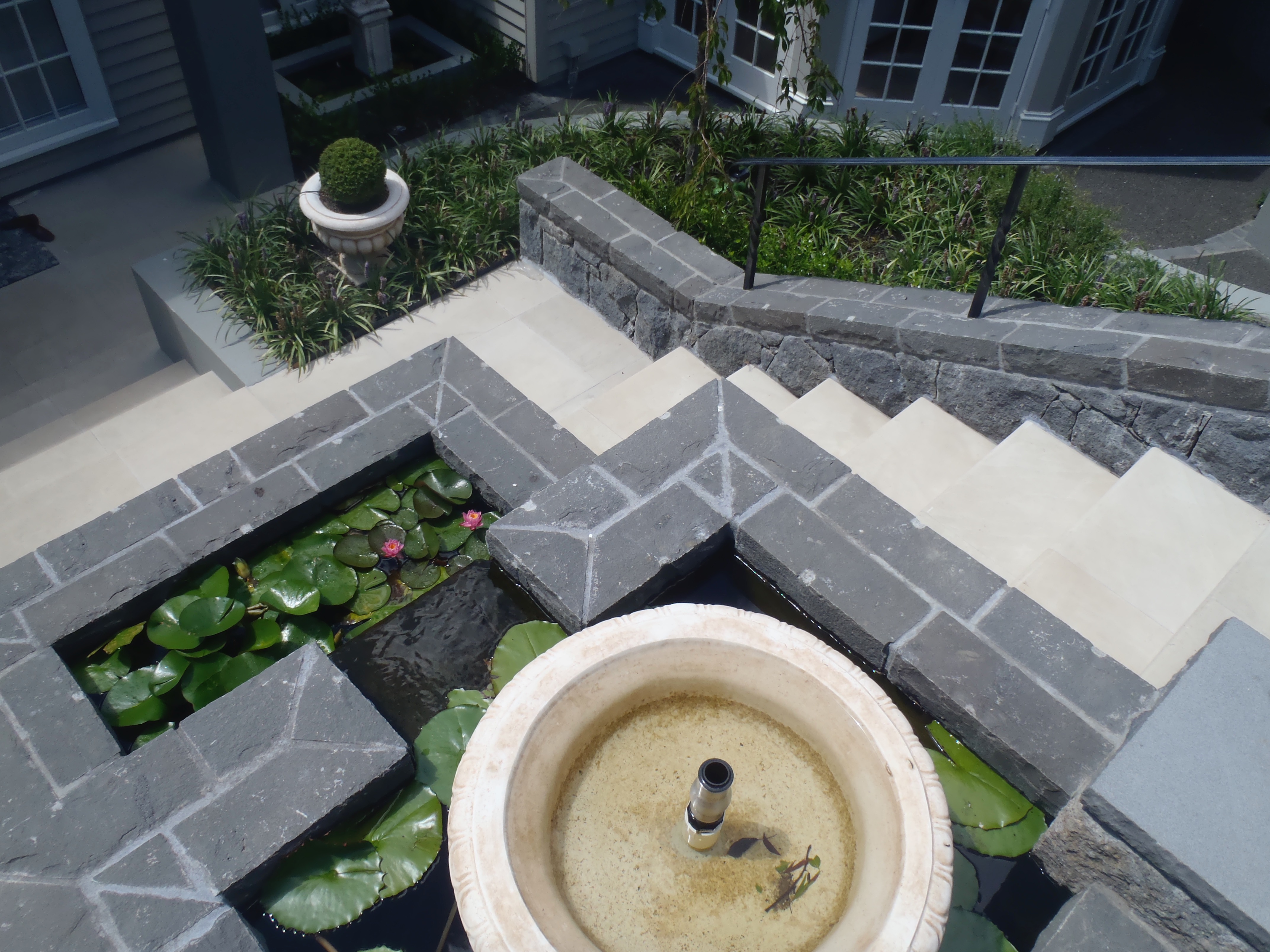 Stone wall borders, paved steps and Pond
